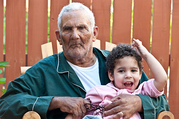 Hispanic grandfather posing sitting in a chair with his grandson