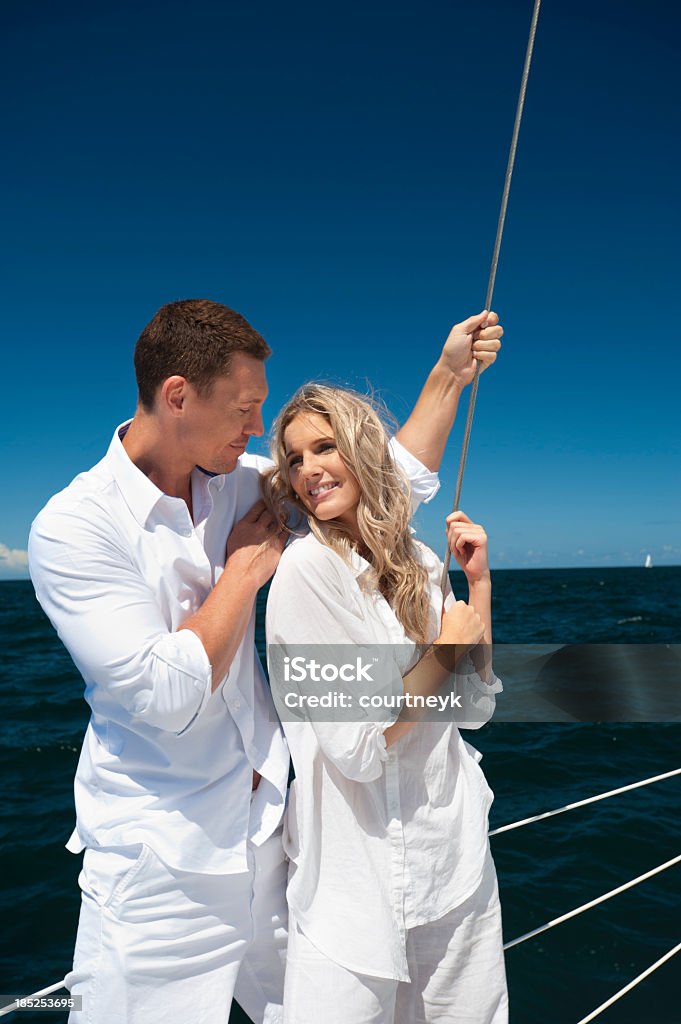 Una giovane coppia in amore a vela nel mare blu - Foto stock royalty-free di Abbracciare una persona