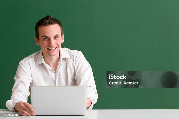 Uomo Sorriso Mentre Si Utilizza Un Computer Portatile Su Sfondo Verde - Fotografie stock e altre immagini di Sfondo a colori