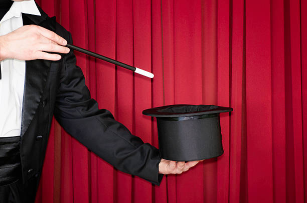 Magic trick on stage Magician on stage doing a trick with top hat magician stock pictures, royalty-free photos & images