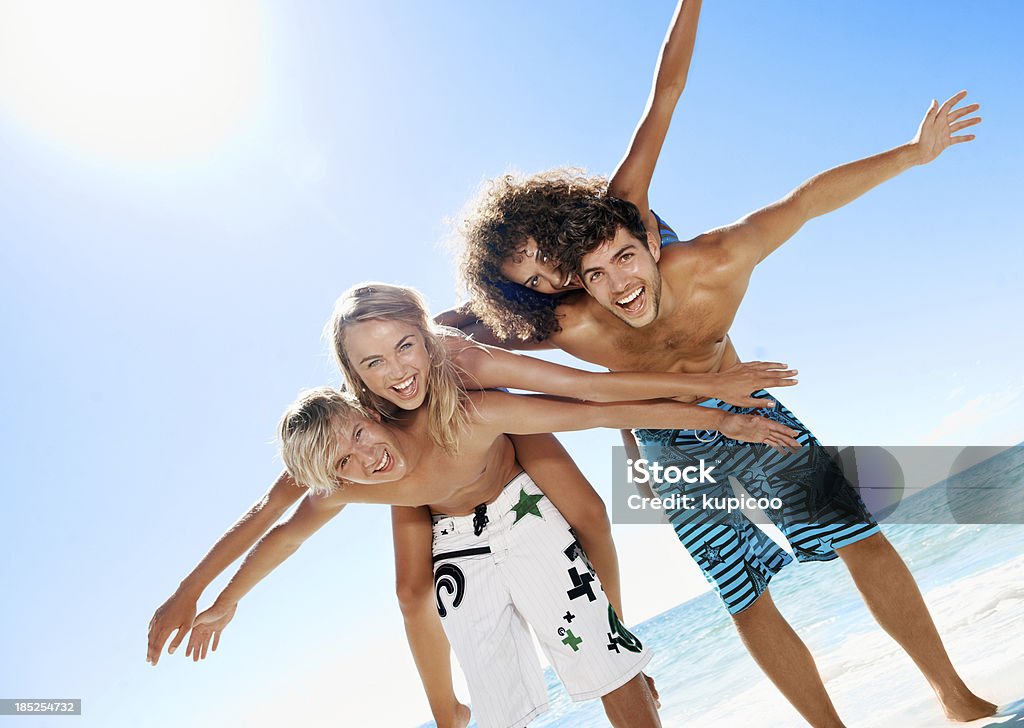 Flying with the freedom of youth Portrait of two teenage boys giving two teenage girls a piggyback ride -  Copyspace Adolescence Stock Photo