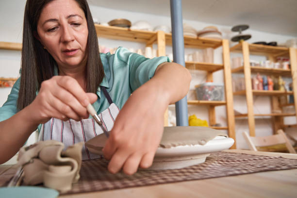 istock Dedicated ceramist perfecting her work in clay, immersed in the artistic process in her workshop 1852548531