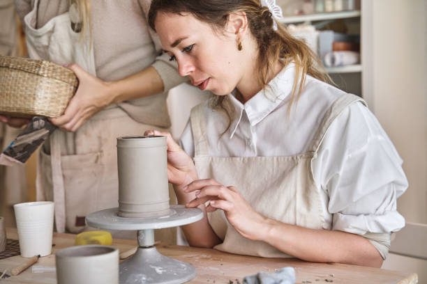 istock Potter woman in apron making a ceramic vase in a pottery workshop. 1852551201