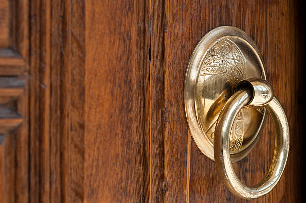 Vintage image of ancient door knocker on a wood stock photo