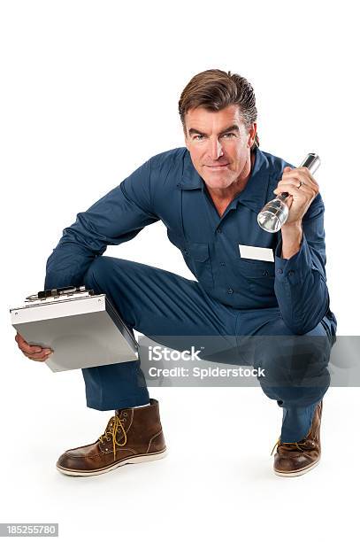 Repairman In Uniform And Flashlight Stock Photo - Download Image Now - Squatting Position, Flashlight, Men