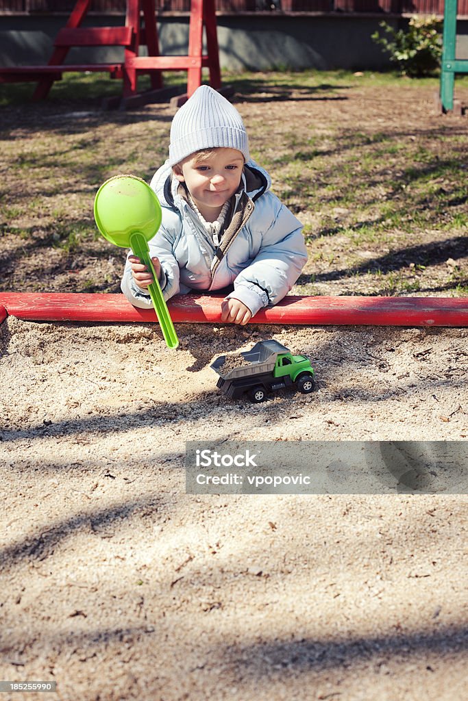 Playground Fun Cute little boy is playing in the sandbox with toy truck and shovel.Similar: Autumn Stock Photo