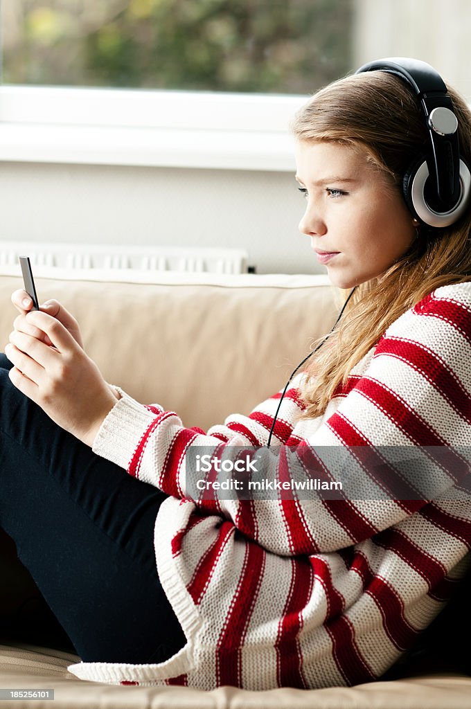 Nastolatek trzyma smartphone i słucha muzyki - Zbiór zdjęć royalty-free (Adolescencja)