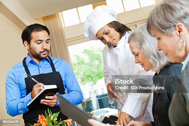 Chef Y Restaurante Camarero Ayudar A Los Clientes En La Orden Foto de stock y más banco de imágenes de Cliente