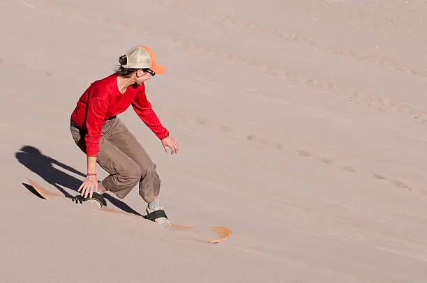 Sand boarding down a large sand duneSandboarding in Chile's Atacama desert's Death Valley