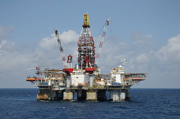 A  free floating dynamically positioned semi-submersible deep water oil drilling platform on location in blue water. An off shore oil rig.