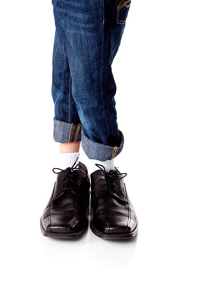 istock Young Boy Wearing Dads Shoes 185256872