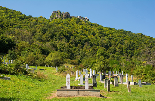 Kulen Vakuf, Bosnia - September 6th 2023. A muslim cemetery on Ostrovica hill just outside Kulen Vakuf Village in the Una National Park. Una-Sana Canton, Federation of Bosnia and Herzegovina. Ostrovica hill in the background