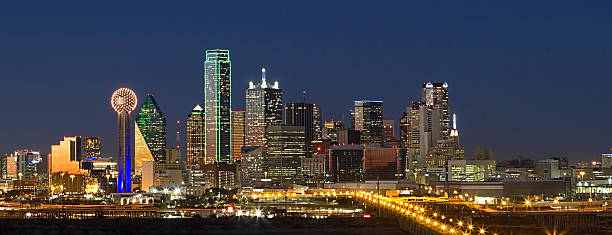 Skyline - Dallas, Texas "Wide-angle shot of Dallas, Texas business district showcasing skyscrapers glowing and lights glimmering at night." reunion tower photos stock pictures, royalty-free photos & images