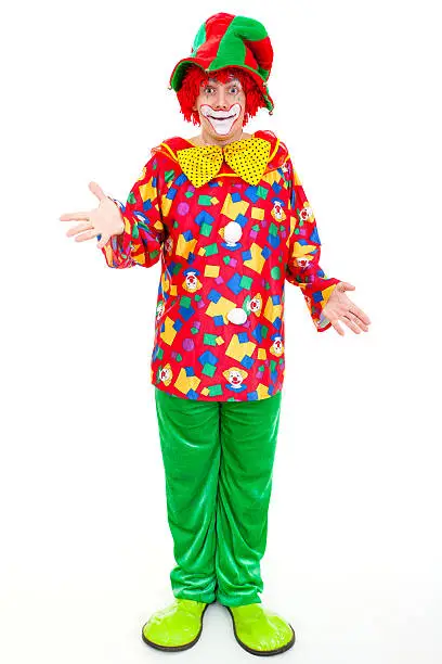 Funny clown standing with hands outstretched against white background.