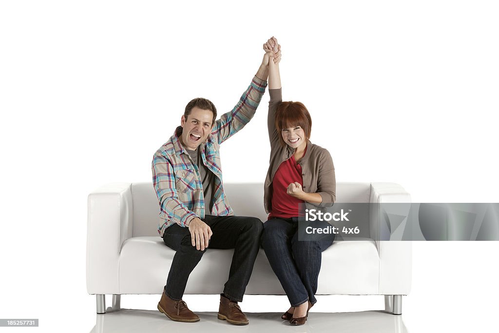 Heureux couple assis sur un canapé - Photo de Femmes libre de droits
