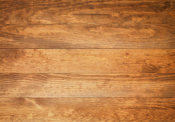 Top view of wooden surface in size XXXL A photograph of five planks of wood laid side by side and running horizontally across the frame.  The wood is light brown with darker brown lines and swirls visible.  The top plank has arches along its length, the points towards the left, the trailing ends towards the right.  The second plank has a large light brown oval in the center top, with thin-lined ovals surrounding it.  The center plank has a slight discoloration to the lower right.  The fourth plank has thick brown lines going from end to end, with lighter brown lines between.  The bottom plank has swirls along the bottom. oak wood material photos stock pictures, royalty-free photos & images