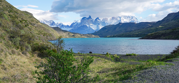 Blue lake on a snowy mountains background and cloudy sky Torres del paine