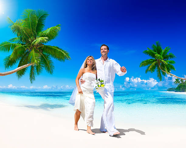 istock Young bride and groom on a white beach with palm trees 185258313