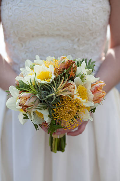 Bride holding yellow springtime bouquet stock photo