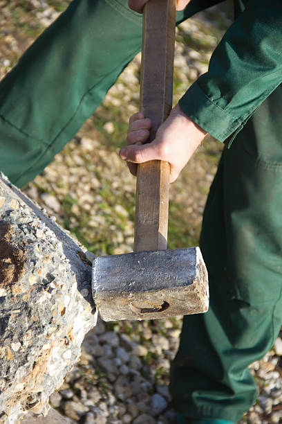 istock male hand with a hammer hit the rock 185258606