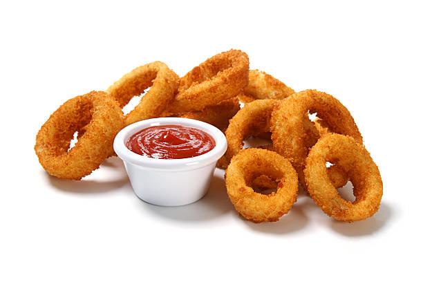 Cooked onion rings with dipping sauce in a white cup stock photo