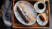 Traditional freshly baked whole apple strudel on wooden table, close up. Fresh homemade pastries with fruit or berry filling