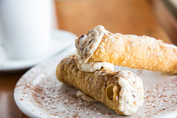 Cannoli Two cannolis arranged on a plate. Shallow depth of field is intentional with critical focus on upper cannoli cannoli photos stock pictures, royalty-free photos & images