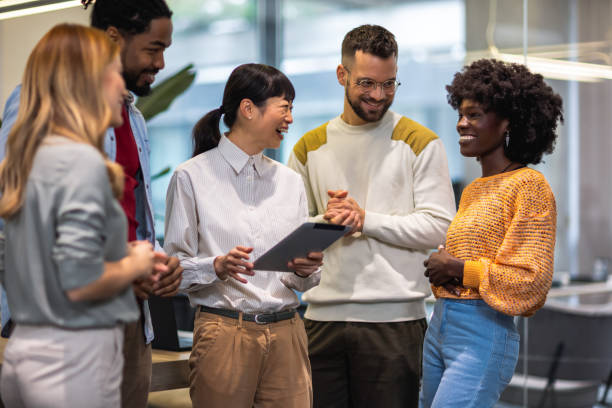 istock Multiethnic colleagues standing together and talking about work in their modern office. 1852597407