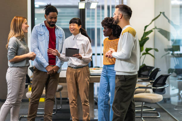 istock Multiethnic colleagues standing together and talking about work in their modern office. 1852597411