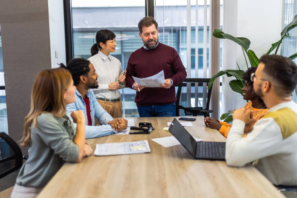 istock International workers group and team leader having teamwork discussion managing project at work in meeting room. 1852599114