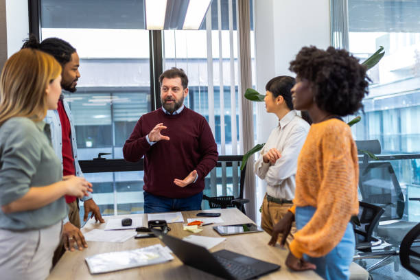 istock International workers group and team leader having teamwork discussion managing project at work in meeting room. 1852599674