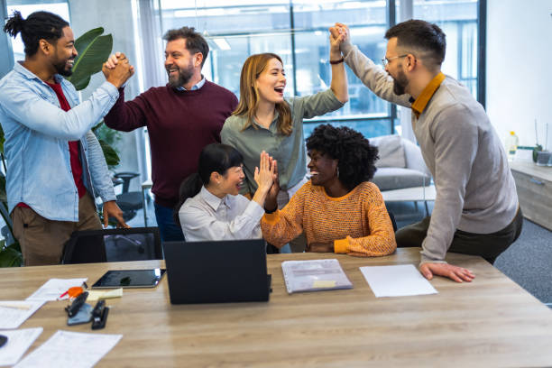 istock International workers group high five after finishing important project. 1852600206
