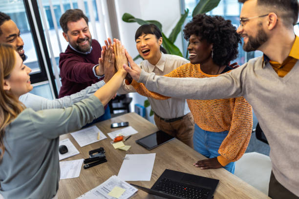 istock International workers group high five after finishing important project. 1852600209