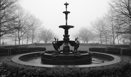 Fountain in the morning fog in early spring.
