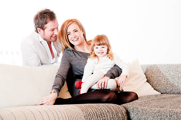 мать, отец и дочь на диван - three person family flash стоковые фото и изображения
