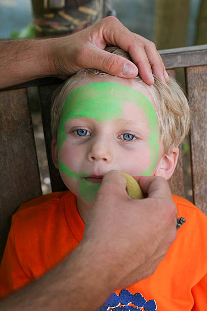 Child getting face painted stock photo