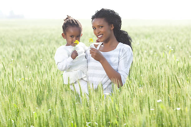 istock Black mother and daughter smelling spring flowers. 185260729