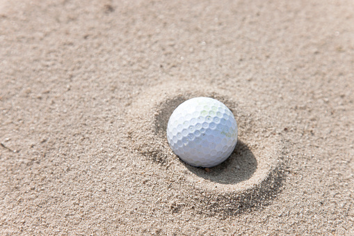 A golf ball in a sand trap.