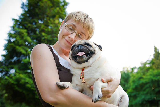 istock Young woman with her dog in a park 185260872