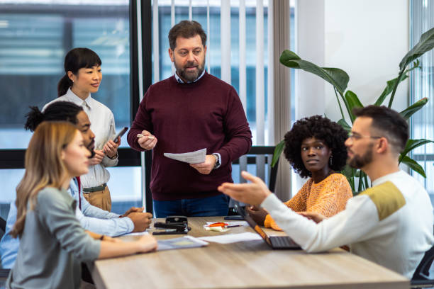 istock International workers group and team leader having teamwork discussion managing project at work in meeting room. 1852609315
