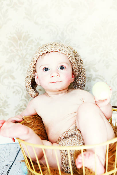 istock Baby Wearing Rabbit Ears Sitting in Antique Egg Basket 185261206
