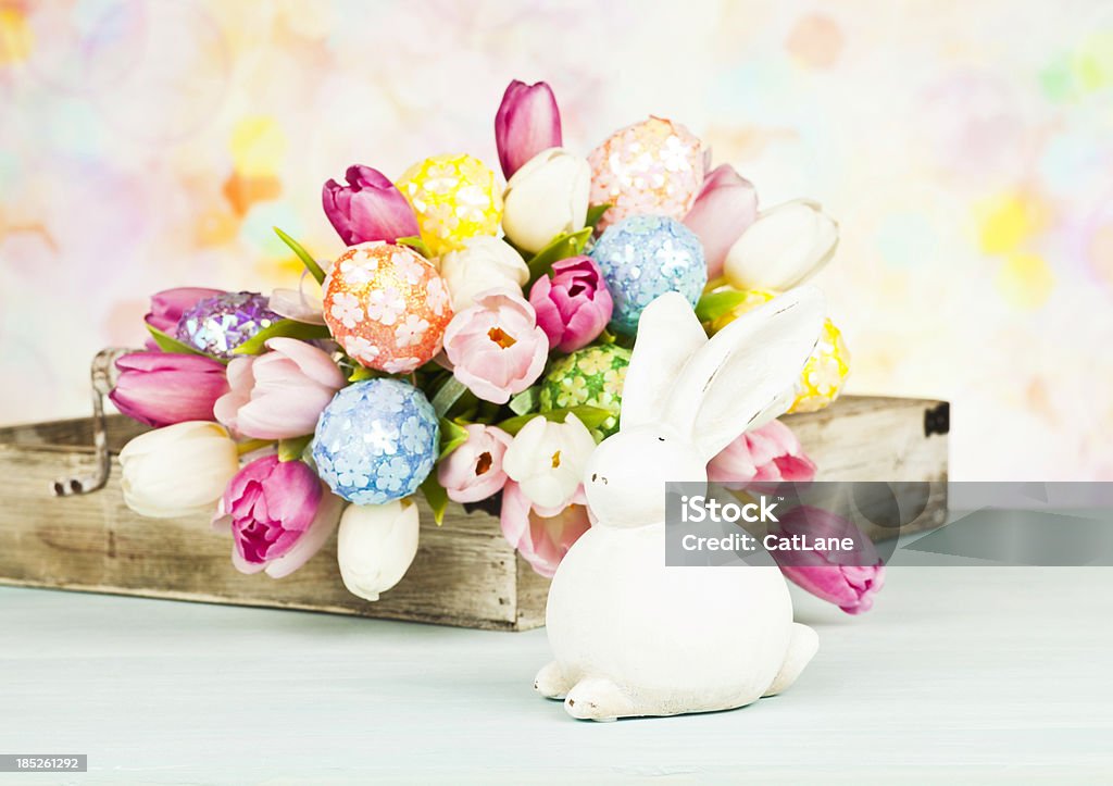 Easter Arrangement with Rabbit Beautiful Easter arrangement with tulips and Easter eggs in rustic tray, and rabbit decoration. Animal Stock Photo