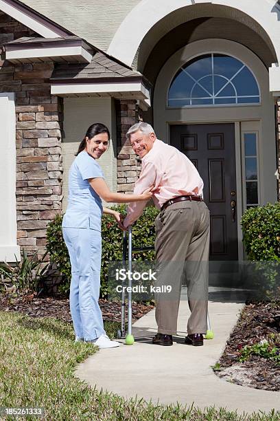 Nurse Helping Senior Man With Walker In Front Of House Stock Photo - Download Image Now