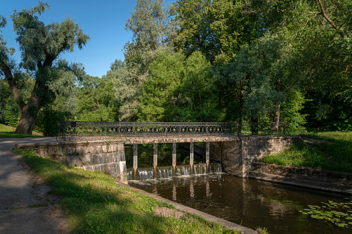 Slavyanka River and the Black Bridge in the Pavlovsk Palace and Park Complex on a sunny summer day, Pavlovsk, Saint Petersburg, Russia