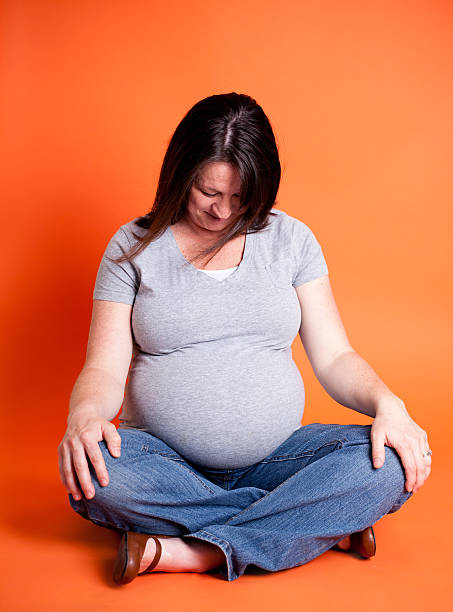 Young Pregnant Mother Isolated on Orange