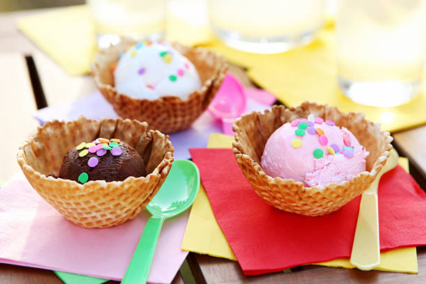 Close-up view of various flavors of ice cream topped with syrup on a restaurant table.