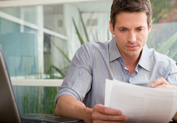 Adult man looking over papers stock photo