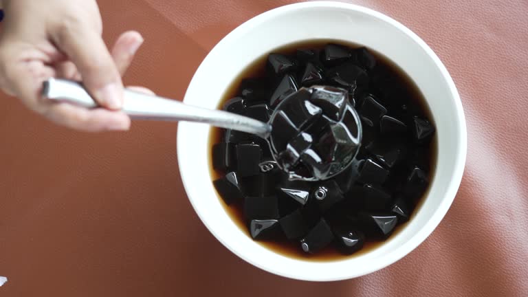 Thai Sweet dessert grass jelly with Ice in white bowl. A kind of Chinese vegetable is black jelly or Herbs can relieve heat in human body system and Aphthous stomatitis in summertime.