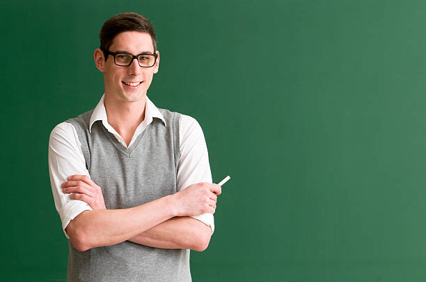 student at blackboard smiling student / teacher with glasses at blackboard nerd sweater stock pictures, royalty-free photos & images