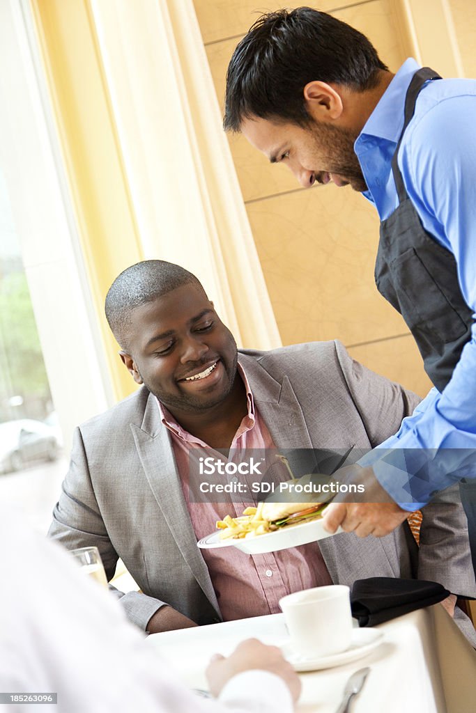 Joven hombre profesional de recibir comida del restaurante servidor - Foto de stock de Bocadillo libre de derechos